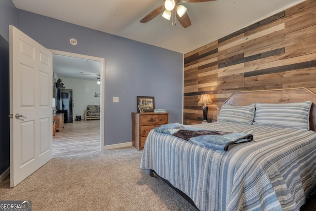 625 Sunnyside Shores Rd, Hiawassee, GA 30546 - bedroom featuring an accent wall, baseboards, wood walls, light carpet, and a ceiling fan