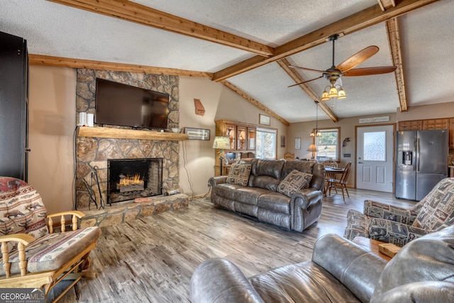 625 Sunnyside Shores Rd, Hiawassee, GA 30546 - living area with vaulted ceiling with beams, ceiling fan, a fireplace, wood finished floors, and a textured ceiling