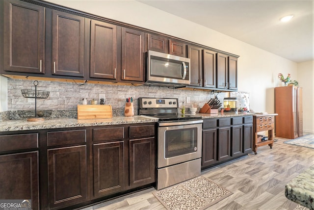 215 Apalachee Dr, Bethlehem, GA 30620 - kitchen featuring dark brown cabinetry, appliances with stainless steel finishes, decorative backsplash, and light stone counters