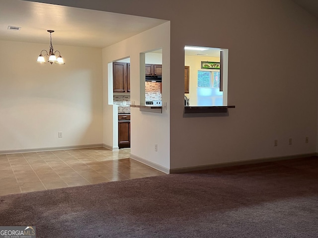 interior space featuring visible vents, baseboards, a notable chandelier, and light carpet