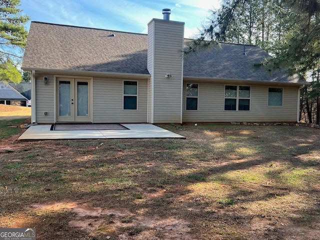 rear view of house featuring french doors, a chimney, a shingled roof, and a patio area