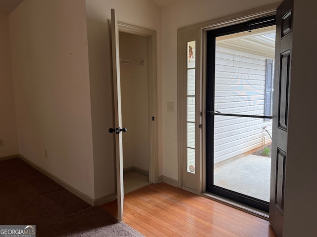 entryway with baseboards and light wood-style flooring