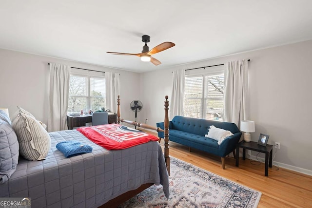 bedroom featuring baseboards, light wood-style floors, and a ceiling fan
