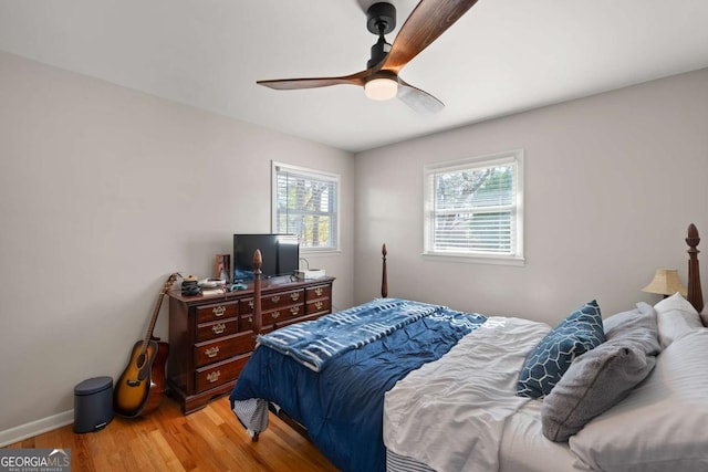 bedroom featuring ceiling fan, baseboards, and wood finished floors
