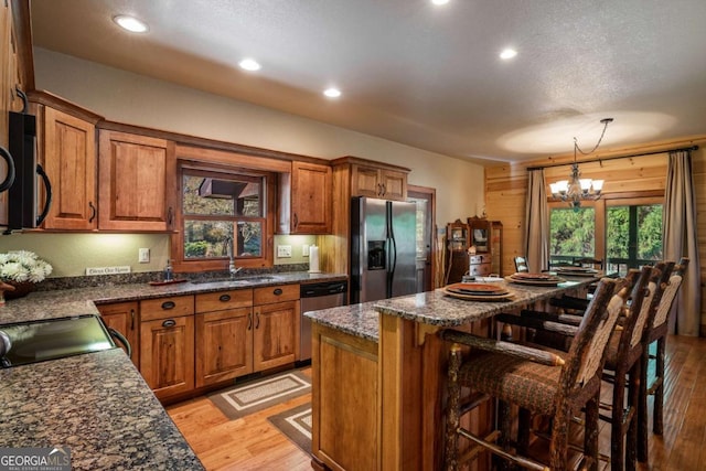 2778 Kelly Ln, Hiawassee, GA 30546 - kitchen with stainless steel appliances, brown cabinetry, a chandelier, a kitchen island, and a kitchen breakfast bar