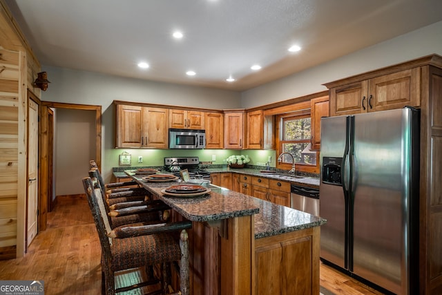 2778 Kelly Ln, Hiawassee, GA 30546 - kitchen with appliances with stainless steel finishes, light wood-style floors, recessed lighting, brown cabinets, and a breakfast bar