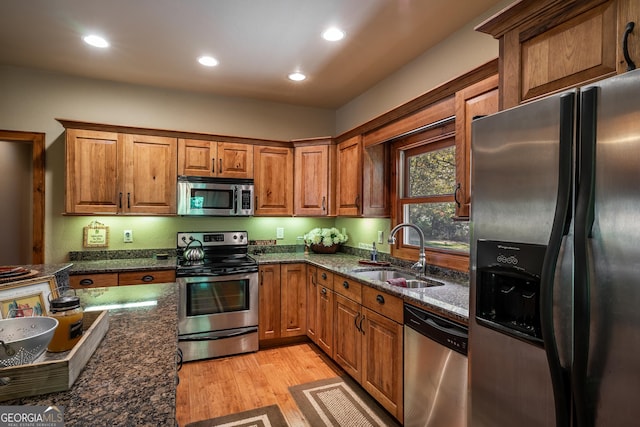 2778 Kelly Ln, Hiawassee, GA 30546 - kitchen featuring stainless steel appliances, light wood-type flooring, brown cabinetry, dark stone countertops, and recessed lighting