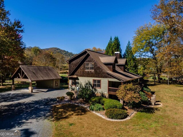 2778 Kelly Ln, Hiawassee, GA 30546 - view of front of home featuring gravel driveway, a chimney, a front yard, a carport, and a mountain view