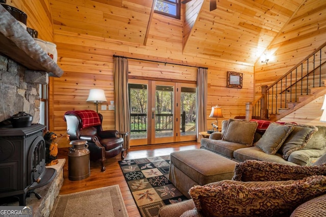 2778 Kelly Ln, Hiawassee, GA 30546 - living room featuring a wood stove, wooden walls, wood finished floors, stairs, and high vaulted ceiling