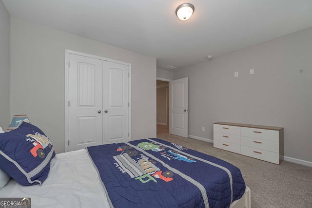 carpeted bedroom with baseboards and a closet