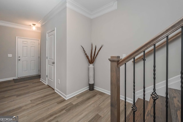 stairway featuring crown molding, baseboards, and wood finished floors