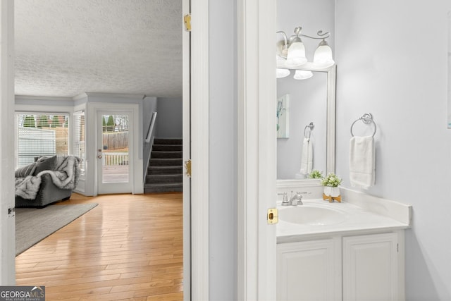 bathroom with wood finished floors, a textured ceiling, and vanity
