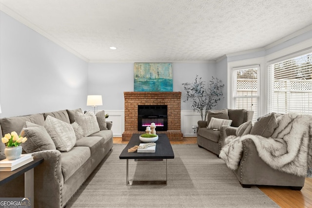 living area with wainscoting, wood finished floors, and ornamental molding