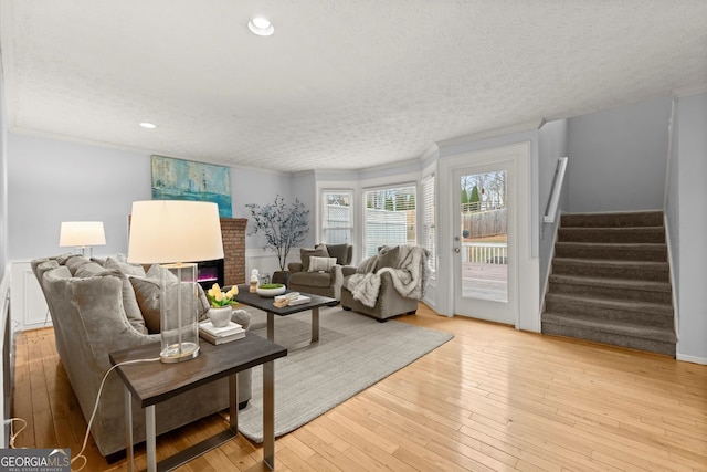 living room with wood-type flooring, stairway, a textured ceiling, and recessed lighting