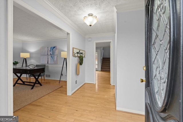 entryway featuring light wood-type flooring, baseboards, a textured ceiling, and stairway