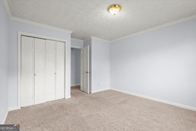 unfurnished bedroom featuring crown molding, a textured ceiling, a closet, carpet, and baseboards
