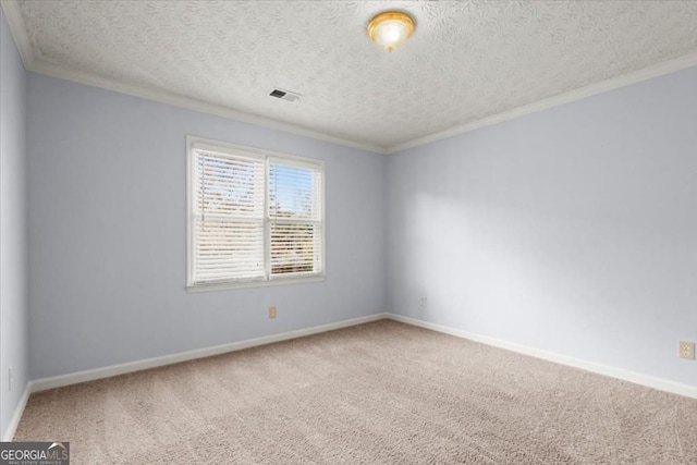 empty room featuring baseboards, visible vents, carpet, and crown molding