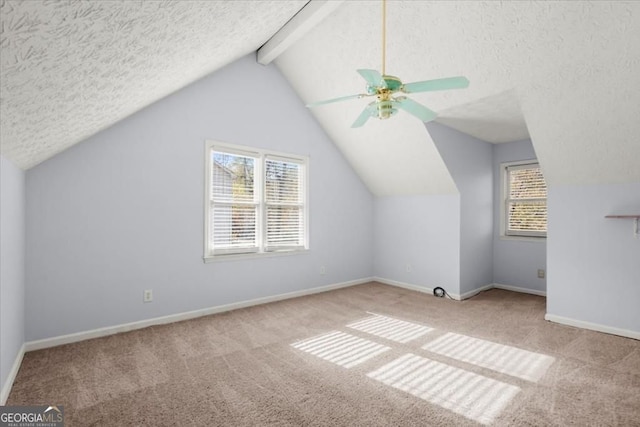 bonus room with a ceiling fan, a healthy amount of sunlight, vaulted ceiling with beams, and carpet