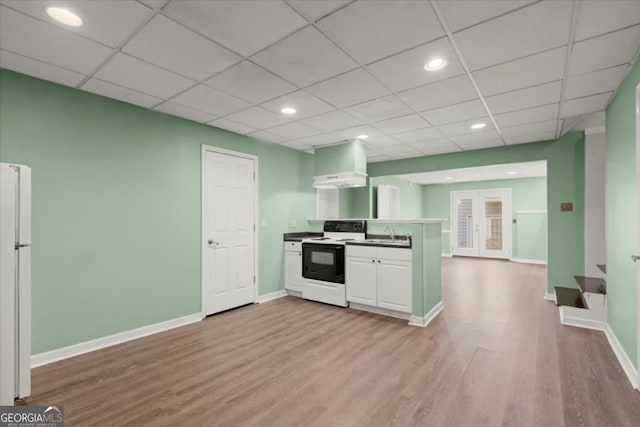 kitchen featuring light wood-style flooring, freestanding refrigerator, baseboards, recessed lighting, and range with electric stovetop