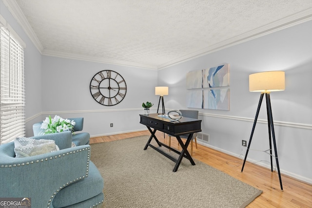office with visible vents, wood finished floors, and crown molding