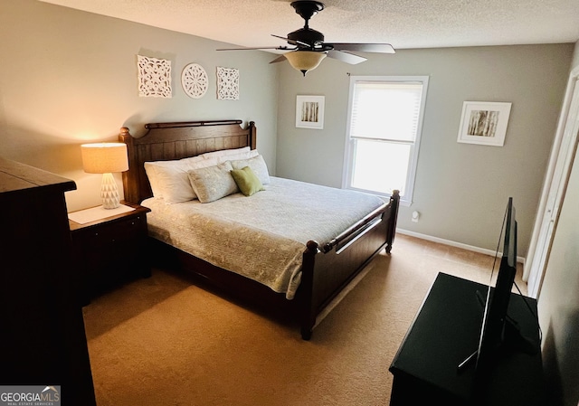 bedroom with ceiling fan, a textured ceiling, carpet flooring, and baseboards