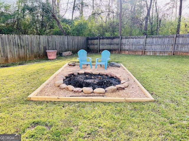 view of yard with a fire pit and a fenced backyard