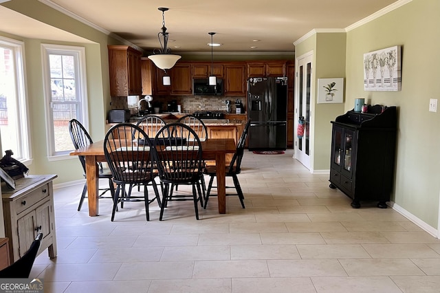 dining area with ornamental molding, light tile patterned flooring, and baseboards