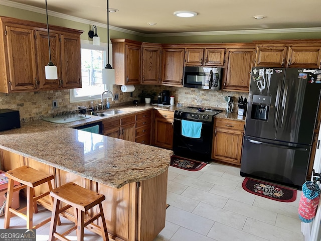 kitchen with a sink, a peninsula, brown cabinetry, black appliances, and light stone countertops