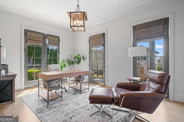 office featuring a chandelier, light wood-type flooring, and ornamental molding