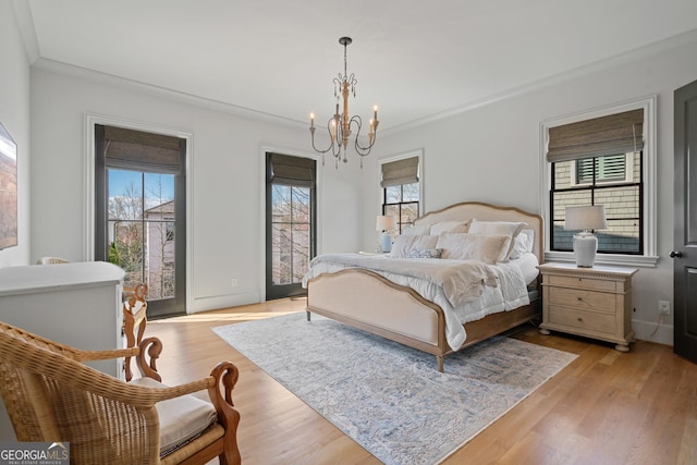 bedroom featuring a chandelier, light wood-style flooring, crown molding, and access to outside
