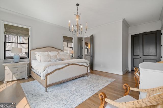 bedroom featuring a chandelier, crown molding, wood finished floors, and baseboards
