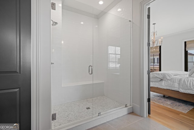 ensuite bathroom with a shower stall and a chandelier