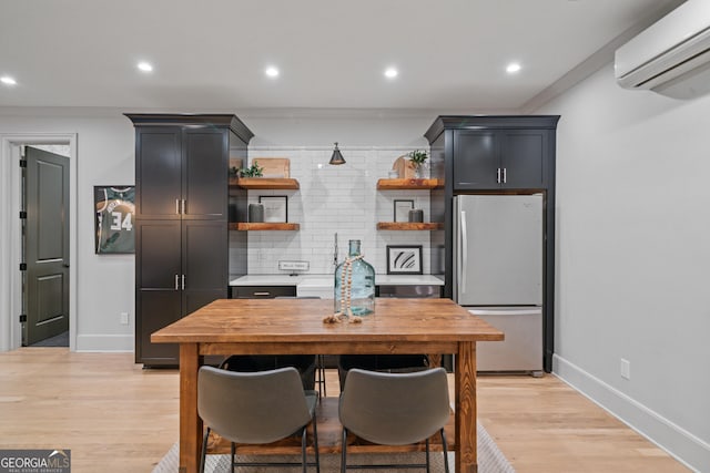 kitchen with freestanding refrigerator, open shelves, an AC wall unit, tasteful backsplash, and light countertops
