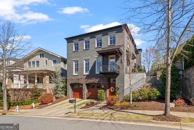 view of front facade with driveway, a garage, and stairway