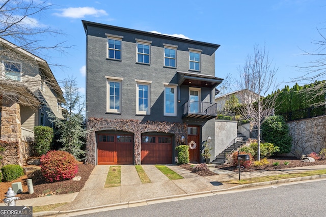 view of front of property with stairs, concrete driveway, a garage, and a balcony