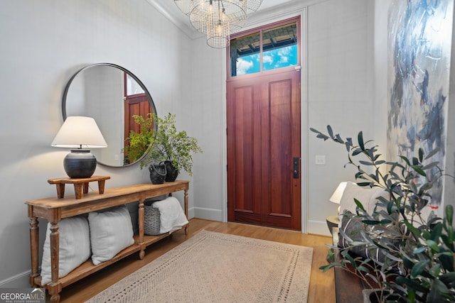 entryway with a chandelier, wood finished floors, and baseboards