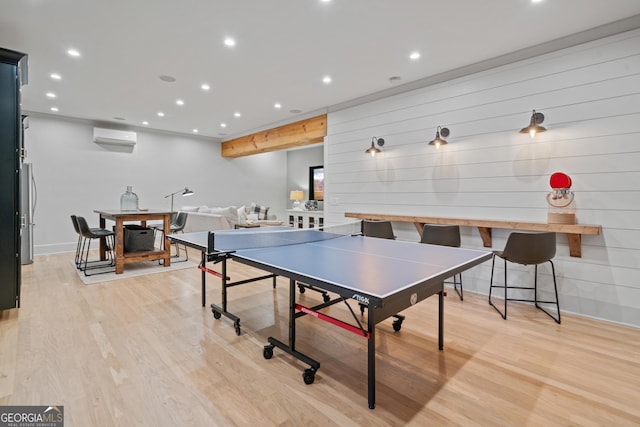 rec room with a wall unit AC, light wood-style floors, baseboards, and recessed lighting