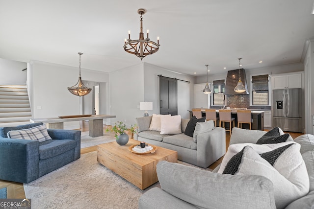 living area featuring a barn door, stairs, light wood finished floors, and recessed lighting