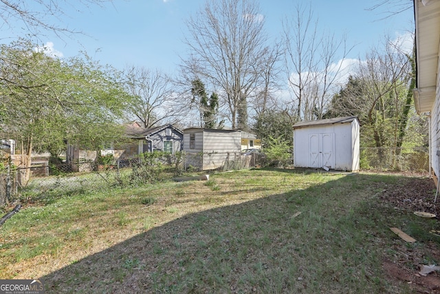 view of yard with an outbuilding, a shed, and a fenced backyard