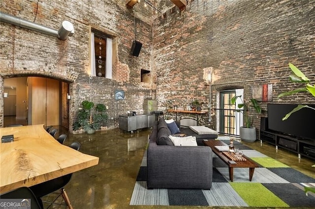 living area featuring arched walkways and a high ceiling
