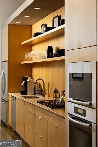 kitchen featuring a sink, light countertops, open shelves, and stainless steel appliances