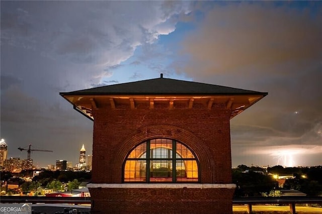 property exterior at dusk with brick siding