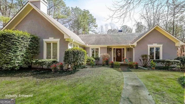 view of front of house with a chimney, stucco siding, and a front yard