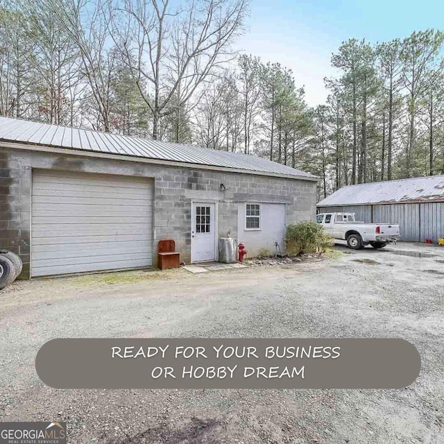 4751 Bill Cheek Rd, Auburn, GA 30011 - view of front facade with driveway, a metal roof, and a garage