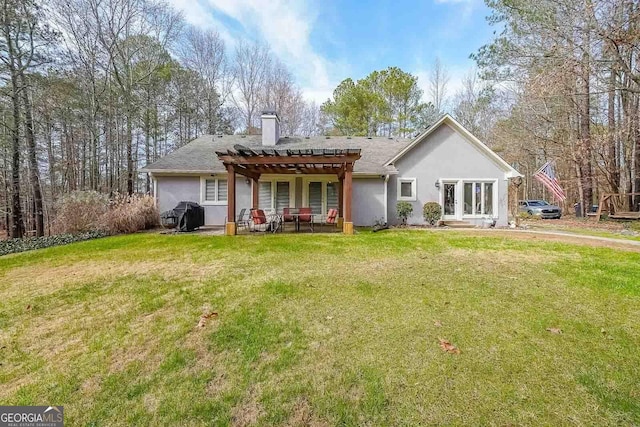 rear view of house featuring a pergola, a patio area, a yard, a chimney, and stucco siding
