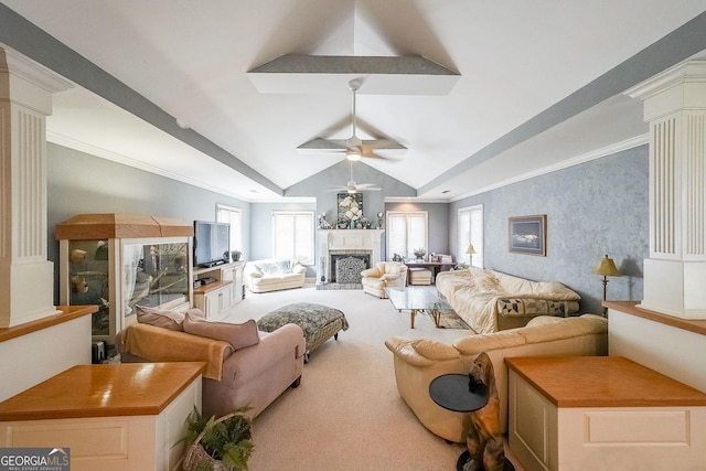 living area with carpet flooring, ceiling fan, a fireplace with raised hearth, vaulted ceiling, and ornate columns