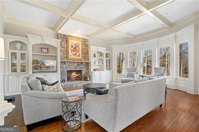 living area with a stone fireplace, dark wood finished floors, built in shelves, beam ceiling, and coffered ceiling