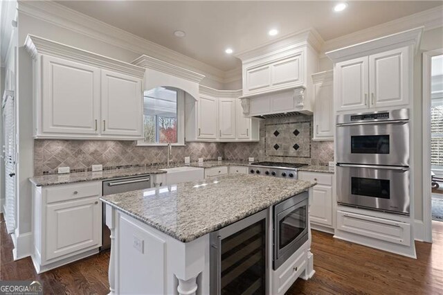 kitchen with white cabinets, stainless steel appliances, a sink, and wine cooler