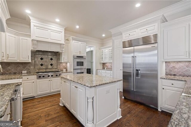 kitchen featuring recessed lighting, tasteful backsplash, white cabinets, and stainless steel appliances