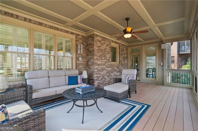 sunroom featuring coffered ceiling, ceiling fan, and outdoor lounge area